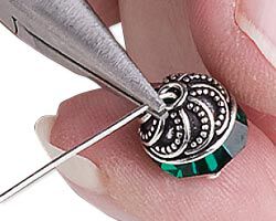 Pliers bending wire over a capped bead